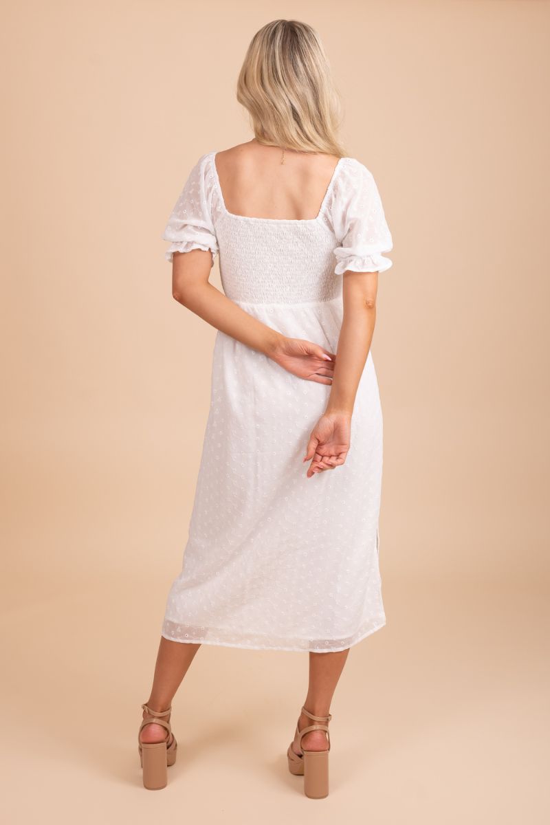 Chic and elegant white dress worn by a stunning model against a neutral tan backdrop