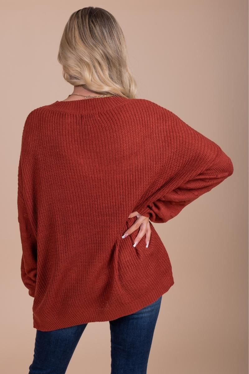 women's red long sleeve knit sweater with textured details on sleeves
