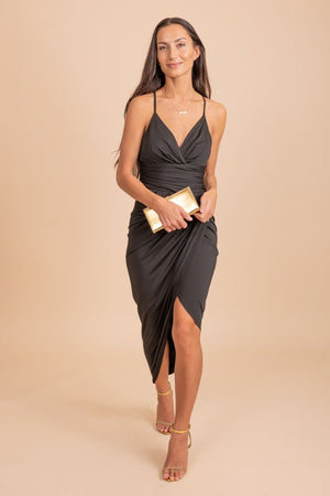 Chic and elegant v-neck faux wrap dress worn by a stunning model against a neutral tan backdrop