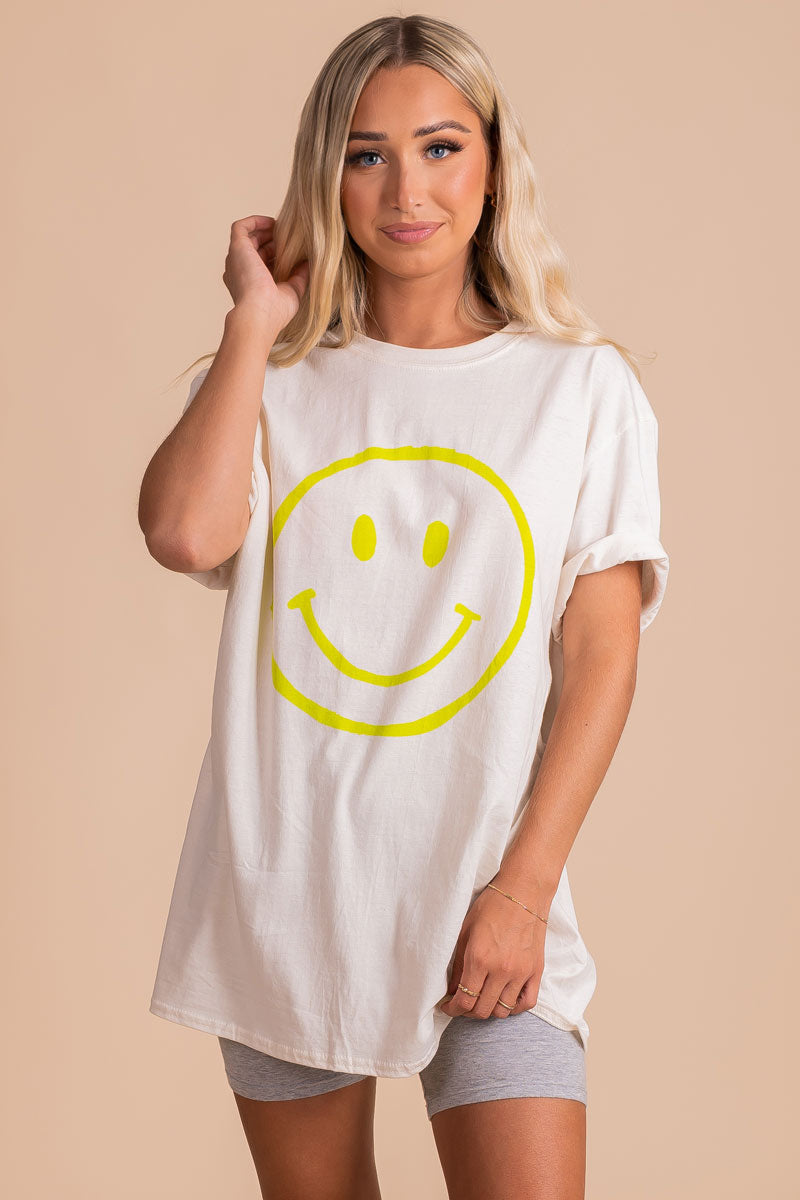 women's boutique tan graphic tee with green smiley face